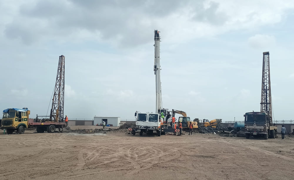 Rotary foundation piling work at a construction project in Dholera, Gujarat using advanced piling equipment for deep foundation installation.